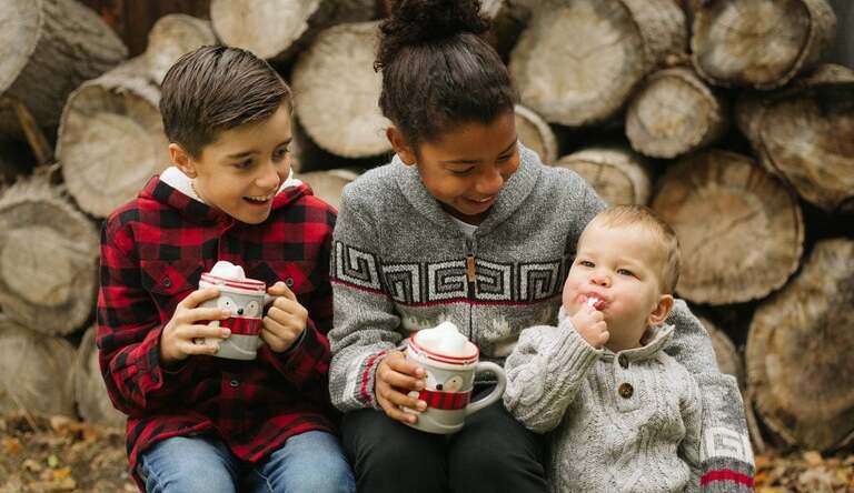 kids at tree farm with hot chocolate and marshmallows