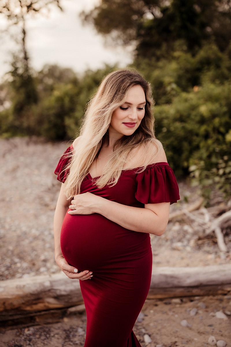 pregnant woman in red dress on the beach