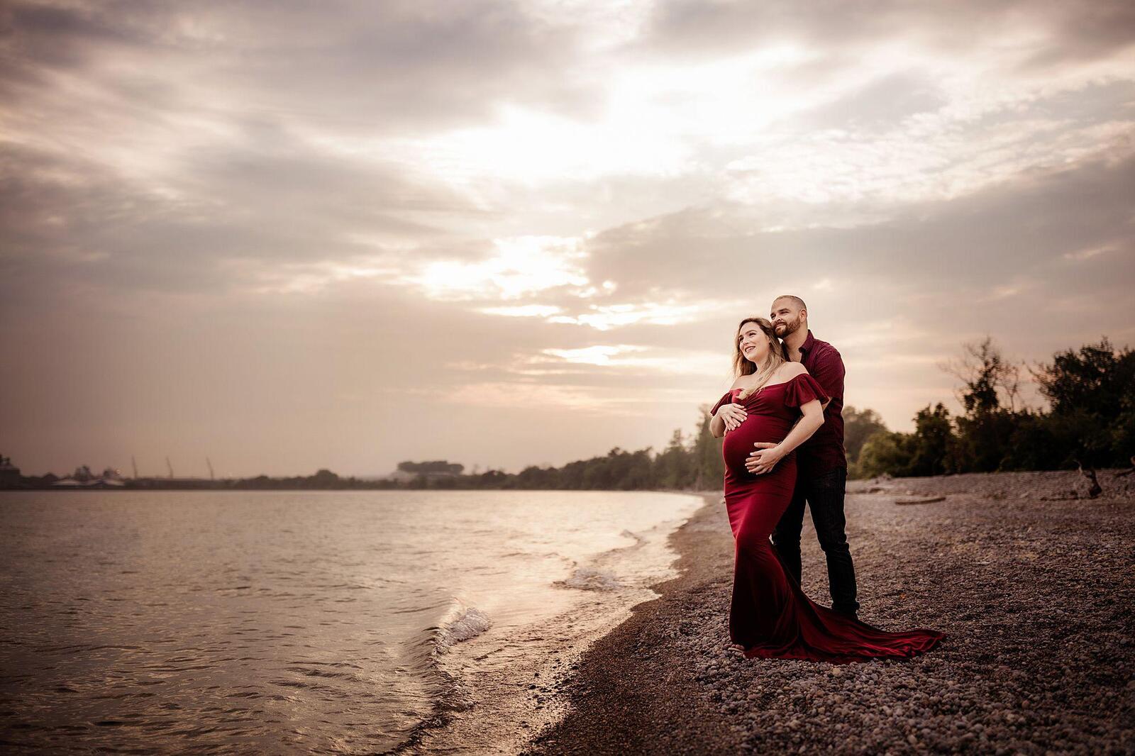 pregnant couple looking out at lake Ontario