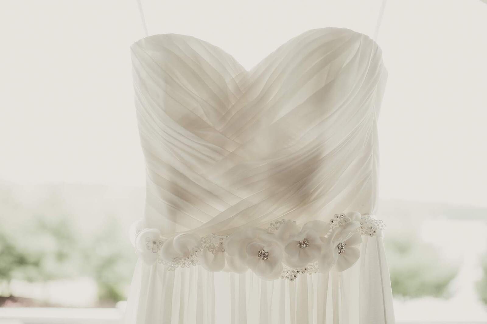 bride's dress hanging in window