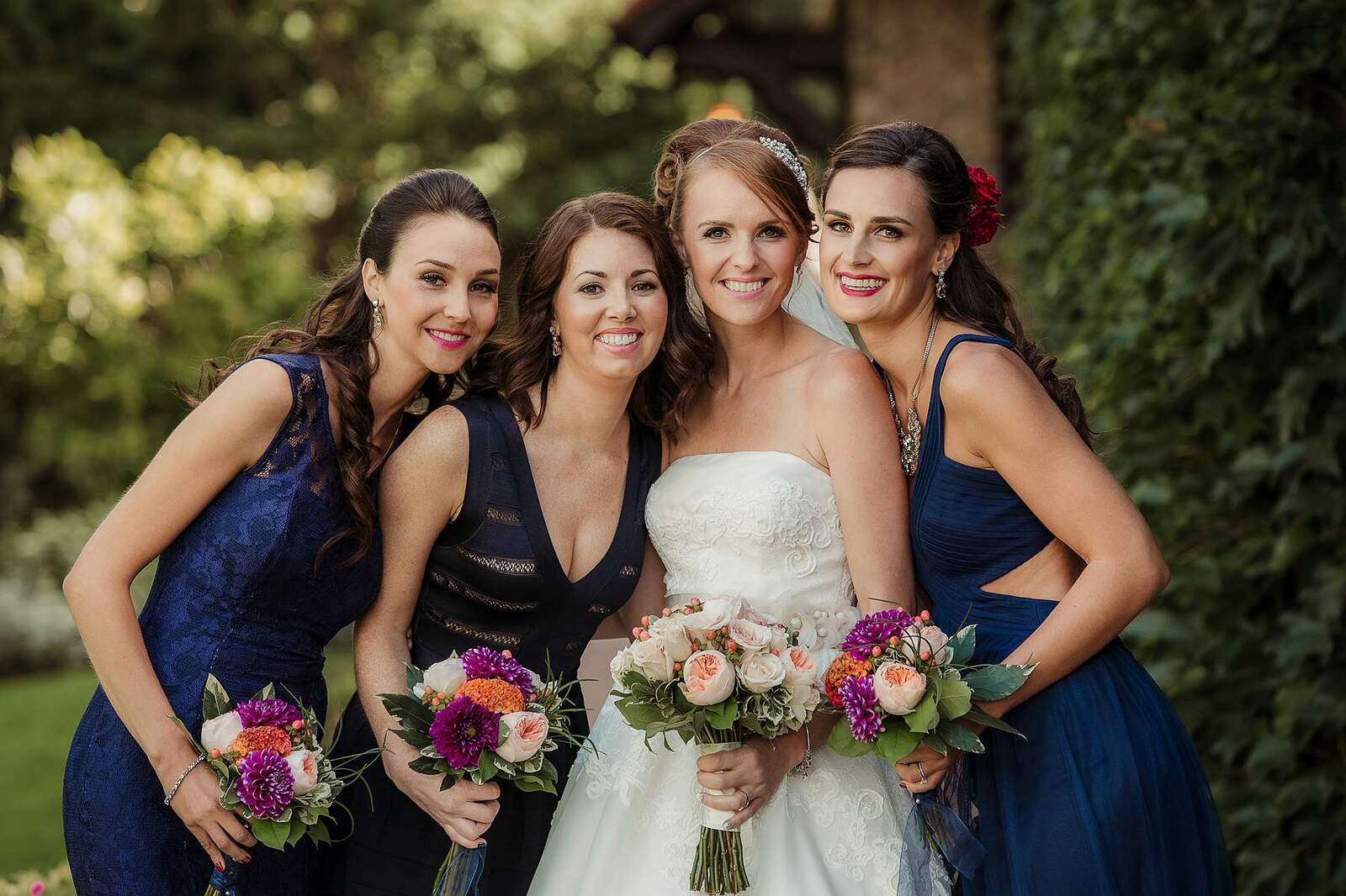 bridesmaids close together with bouquets