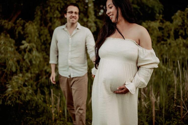 maternity couple looking relaxed and holding hands