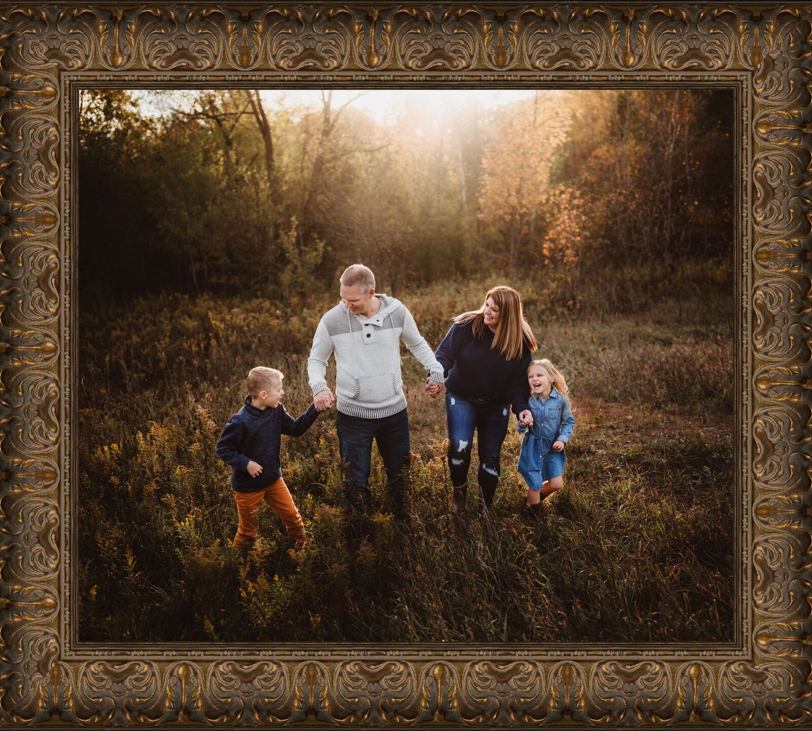 Ornate framed family photo shows a family together in a field, in a bronze frame.